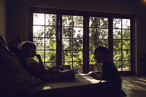 Vater und Tochter im Schlafzimmer in tropischer Umgebung, lizenzfreies Stockfoto