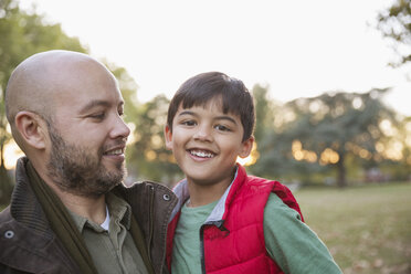 Portrait glücklicher Vater und Sohn im Herbstpark - CAIF23201