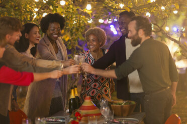 Happy friends toasting wine glasses at dinner garden party - CAIF23206