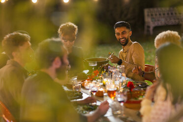 Happy friends enjoying dinner garden party - CAIF23207