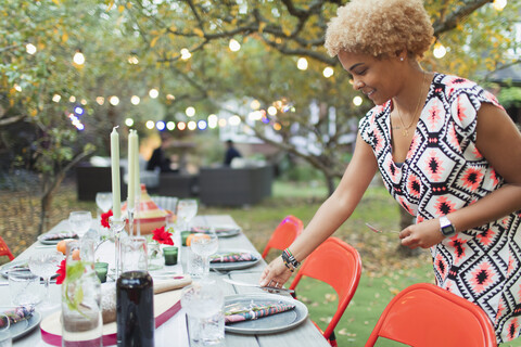 Woman setting table for dinner garden party stock photo