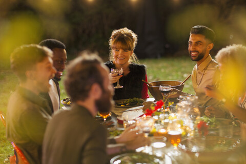 Freunde genießen das Abendessen auf einer Gartenparty, lizenzfreies Stockfoto