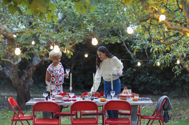 Frauen Freunde decken Tisch für Abendessen Gartenparty - CAIF23222