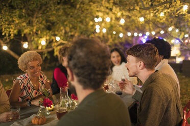 Freunde genießen das Abendessen auf einer Gartenparty - CAIF23229