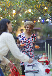 Glückliche Frauen Freunde decken den Tisch für das Abendessen Gartenparty - CAIF23245