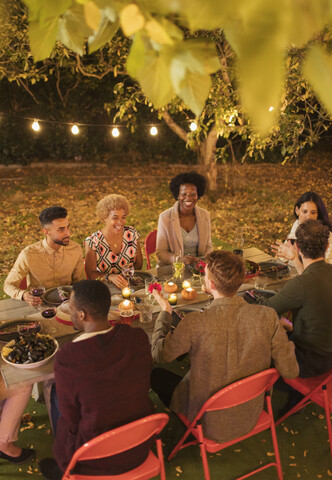 Freunde genießen das Abendessen auf einer Gartenparty, lizenzfreies Stockfoto