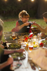 Happy friends toasting wine at dinner garden party - CAIF23260