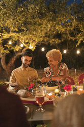 Couple enjoying dinner garden party - CAIF23276