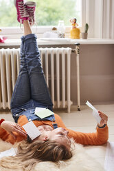 Young female college student studying with flash cards on floor - CAIF23295