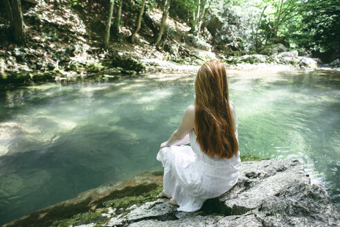 Caucasian woman sitting near river - BLEF00195