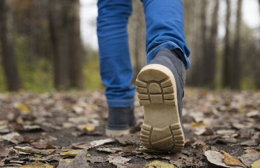 Schuhsohle eines kaukasischen Jungen, der auf Herbstblättern läuft - BLEF00203