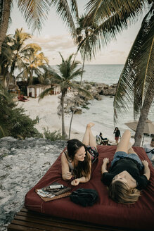 Mexiko, Quintana Roo, Tulum, zwei glückliche junge Frauen entspannen sich am Strand - LHPF00668