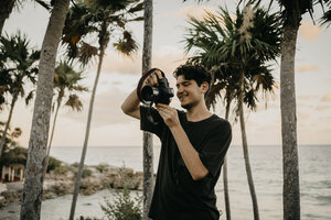 Mexiko, Quintana Roo, Tulum, junger Mann beim Fotografieren am Strand - LHPF00669