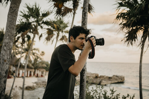 Mexiko, Quintana Roo, Tulum, junger Mann beim Fotografieren am Strand - LHPF00670
