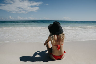 Mexiko, Quintana Roo, Tulum, junge Frau mit Hut am Strand liegend - LHPF00675