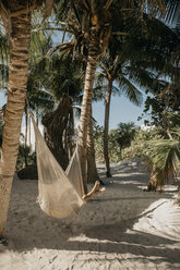 Mexiko, Quintana Roo, Tulum, junge Frau in Hängematte am Strand liegend - LHPF00676