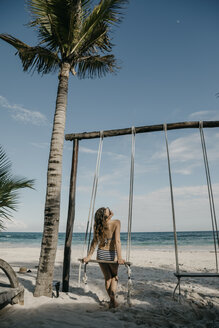 Mexiko, Quintana Roo, Tulum, junge Frau auf einer Schaukel am Strand - LHPF00679