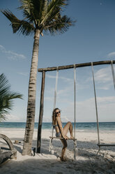 Mexico, Quintana Roo, Tulum, happy young woman on a swing on the beach - LHPF00680