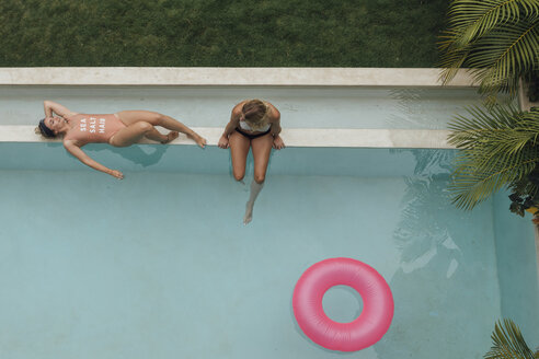 Two young women relaxing at swimming pool - LHPF00683