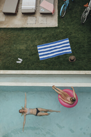 Zwei junge Frauen entspannen sich im Schwimmbad, lizenzfreies Stockfoto