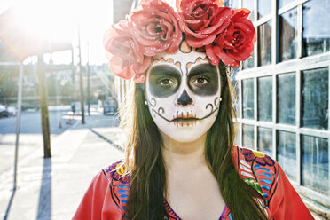 Hispanische Frau auf dem Bürgersteig mit Totenkopf-Gesichtsbemalung - BLEF00233