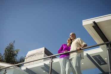Lächelndes Paar auf modernem Balkon stehend - BLEF00246