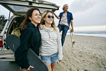 Kaukasische Freunde in der Nähe der Autoluke am Strand mit Skateboards - BLEF00258
