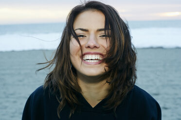 Porträt einer lachenden kaukasischen Frau am Strand - BLEF00261