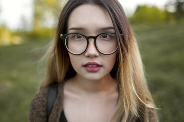 Asiatisches Teenager-Mädchen mit Brille im Feld - BLEF00268