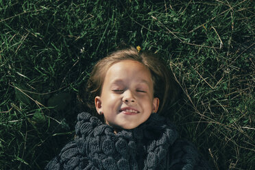 Kaukasisches Mädchen mit Pullover im Gras liegend - BLEF00271