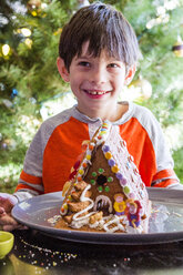Mixed Race boy with gingerbread house on plate - BLEF00315