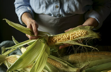 Close up of Caucasian woman shucking corn - BLEF00349