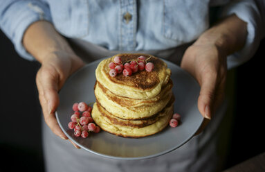 Close up of Caucasian woman holding plate of pancakes - BLEF00350