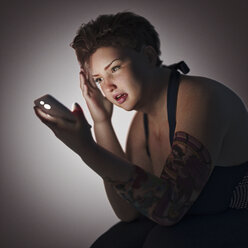 Overweight woman texting on cell phone - BLEF00356