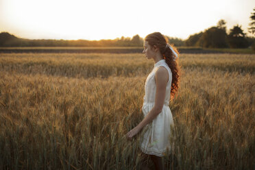 Pensive Caucasian girl standing in field of wheat - BLEF00431