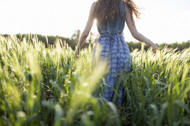 Caucasian woman walking in field of tall grass - BLEF00446
