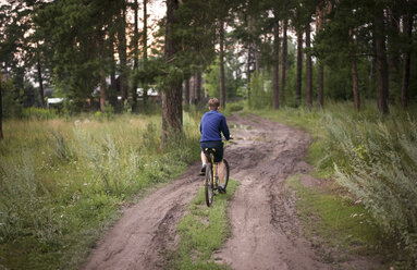 Kaukasische Teenager-Jungen fahren Fahrrad im Wald - BLEF00497