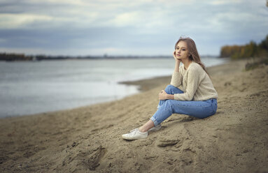 Pensive woman sitting on beach - BLEF00499