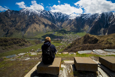 Kaukasischer Mann bewundert die malerische Aussicht auf ein Dorf im Tal - BLEF00501