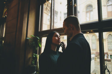 Caucasian couple embracing near window - BLEF00588