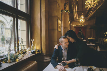 Kaukasisches Paar trinkt Wein und umarmt sich im Restaurant - BLEF00592
