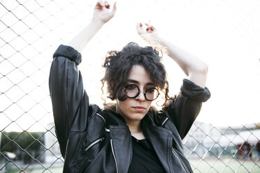 Pensive Caucasian woman leaning on chain-link fence - BLEF00624