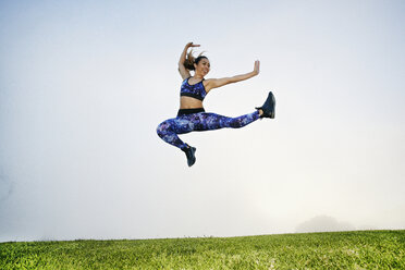 Mixed race woman exercising and jumping in field - BLEF00630