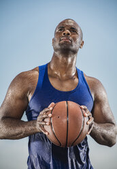 Nachdenklich schwitzender schwarzer Mann mit Basketball in der Hand - BLEF00655