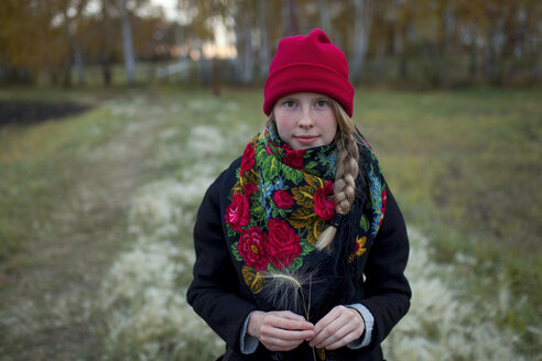 Porträt einer kaukasischen Frau mit Schal und Strumpfmütze, die Heusamen hält - BLEF00705