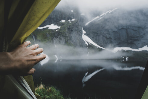 Hand opening tent flap near foggy river - BLEF00723