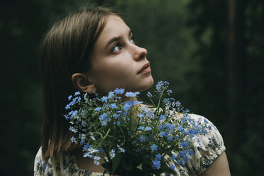 Caucasian woman holding flowers and looking up - BLEF00746