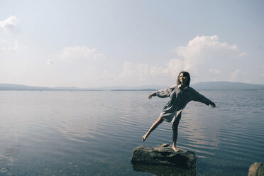Kaukasisches Mädchen steht auf einem Felsen im See - BLEF00758