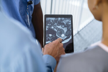 Close up of doctor and nurses viewing image on digital tablet - BLEF00766