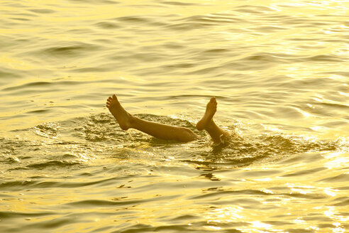 Füße eines kaukasischen Jungen, der aus dem Wasser ragt - BLEF00779
